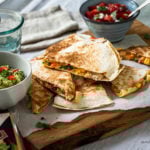 Quesadilla mit Guacamole und Tomatensalsa am Tisch