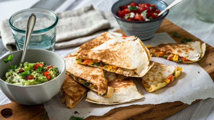quesadilla Quesadilla aufgeschnitten mit Guacamole und Tomatensalsa