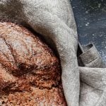 Ein Laib Sodabrot, daneben Mehl und ein Sieb