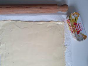 Pizzateig mit Schmelzkäse bestrichen