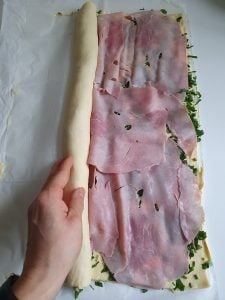 Gefüllter Pizzateig wird eingerollt