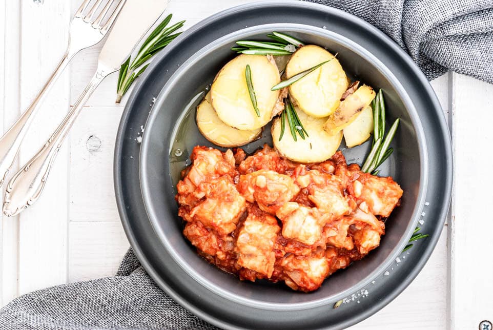 Ein Teller mit Baccala alla livornese und Rosmarinkartoffeln