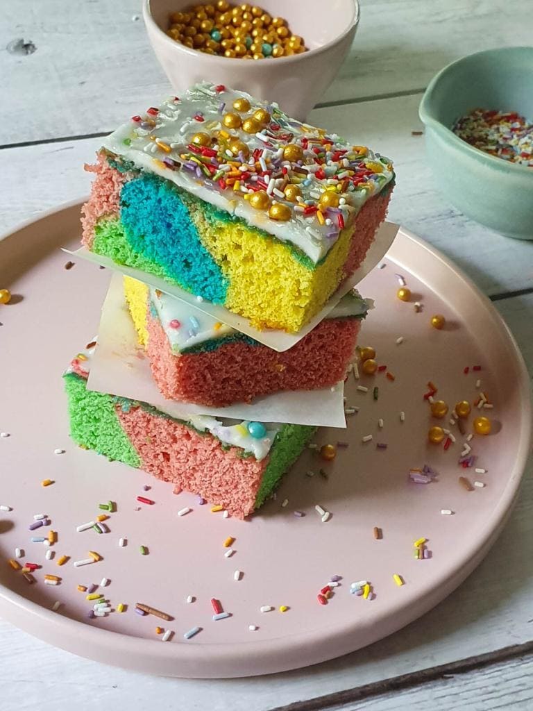 3 Stück bunte Blechkuchen sind auf einem Teller aufgetürmt
