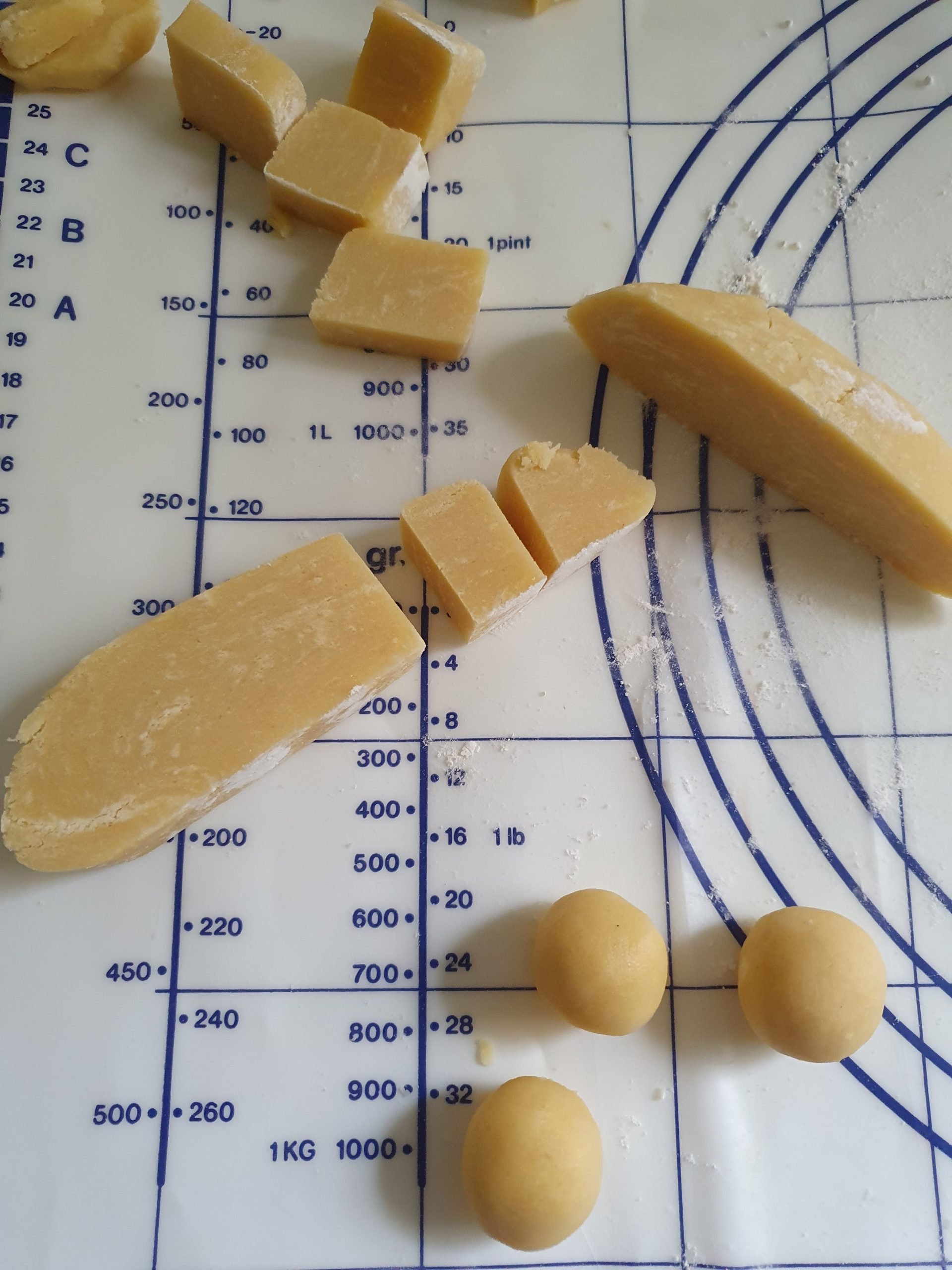 In Stücke geschnittener Mürbeteig liegt auf Arbeitsfläche