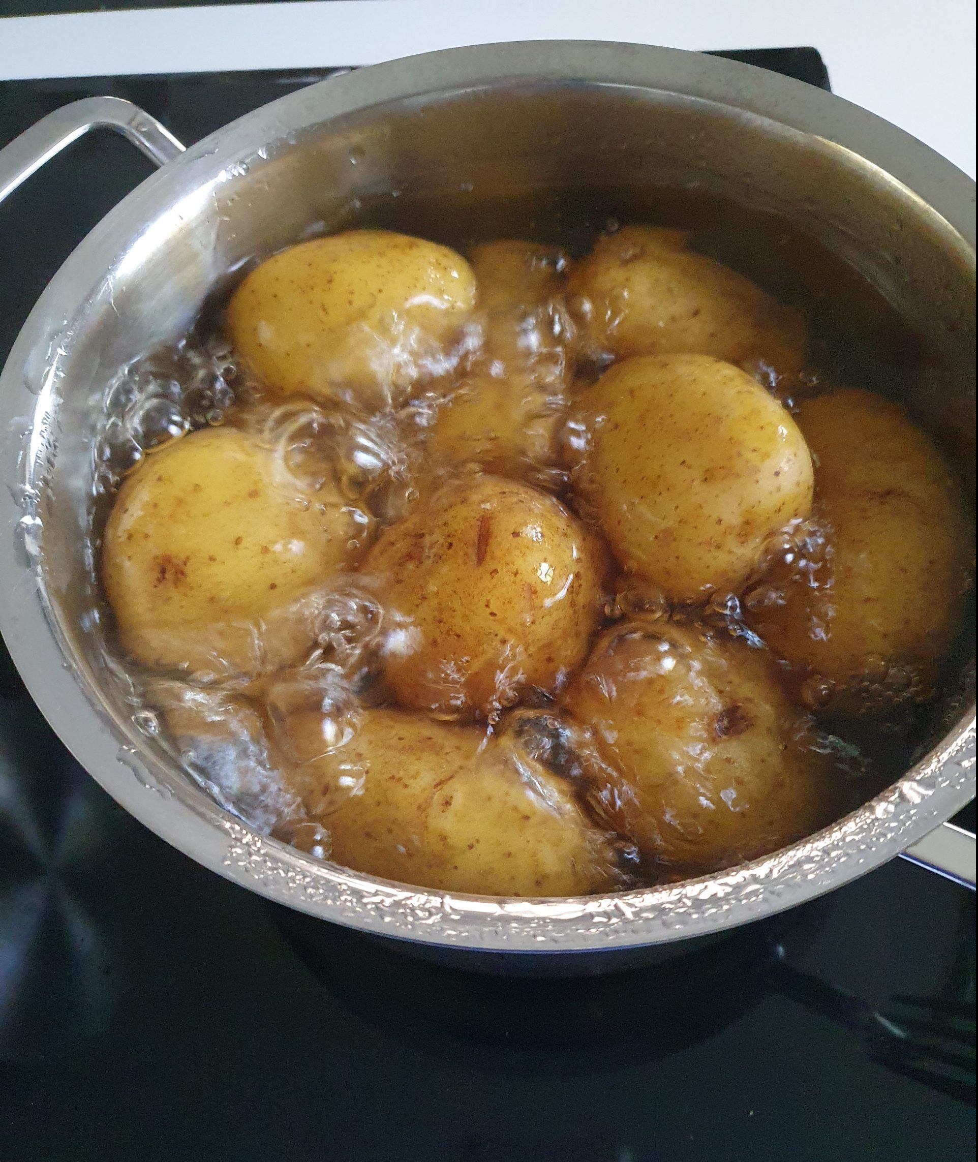 Kartoffeln mit Schale kochen in Kochtopf.