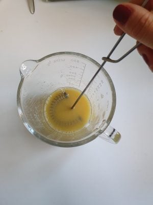 Ein Dressing für Kartoffelsalat wird in einem Messbecher verrührt.