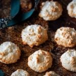 Kokosmakronen liegen auf einem alten Backblech neben einer Schleife