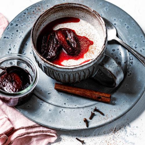 Lebkuchen Panda Cotta ist in einer Tasse mit karamellisierten Pflaumen angerichtet