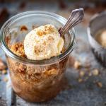Bratapfel Apfel Crumble im Glas mit Vanilleeis auf einem Tablett