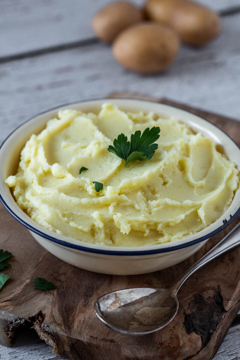 Kartoffelpüree in einer Schale auf einem Holzbrett.