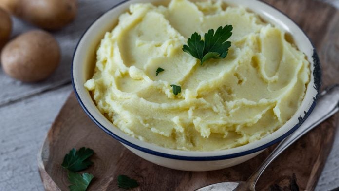 Kartoffelpüree in einer Schale auf einem Holzbrett.