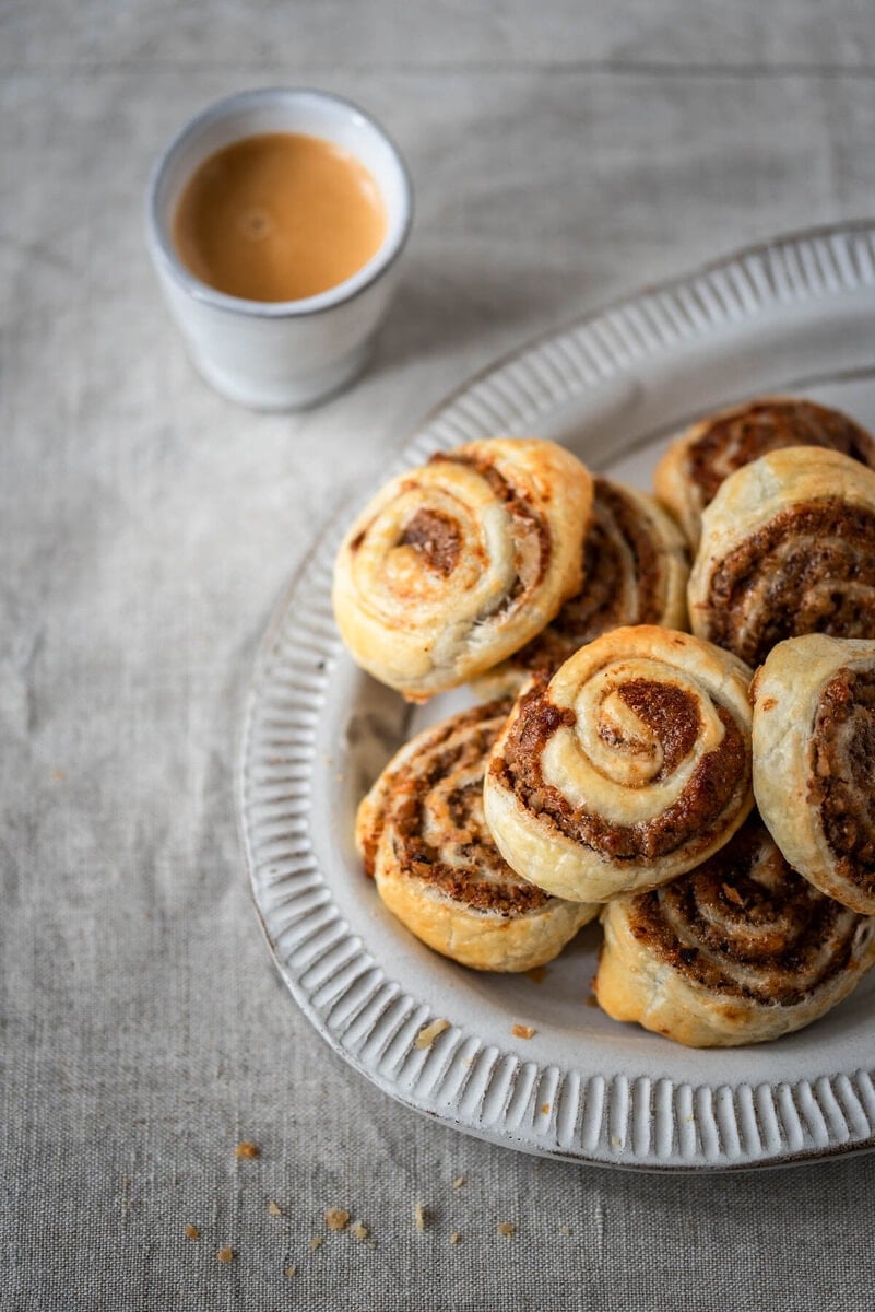 Ein Teller mit Nussschnecken und einem Espresso.