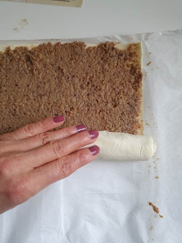 Blätterteig wird von Hand eingerollt.