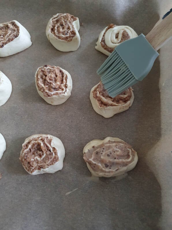 Nussschnecken werden mit Pinsel mit Ei bestrichen.