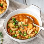 Zwei Suppenschüsseln mit Gemüseeintopf stehen auf einem Tisch.
