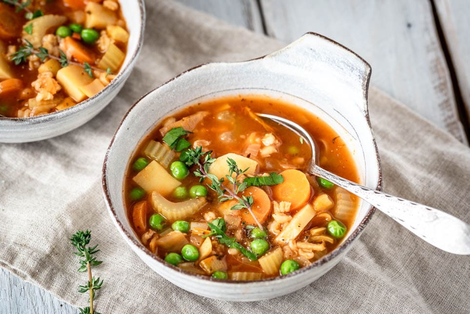 Zwei Suppenschüsseln mit Gemüseeintopf stehen auf einem Tisch.