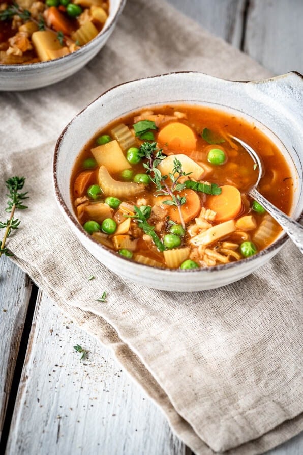 Zwei Suppenschüsseln mit Gemüseeintopf und Pfeffermühle.