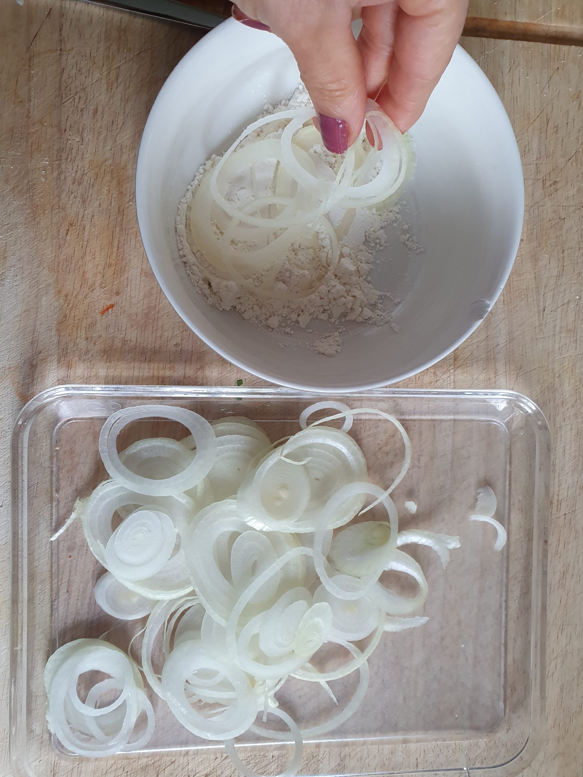 Fein geschnittene Zwiebelringe werden in Mehl gewälzt