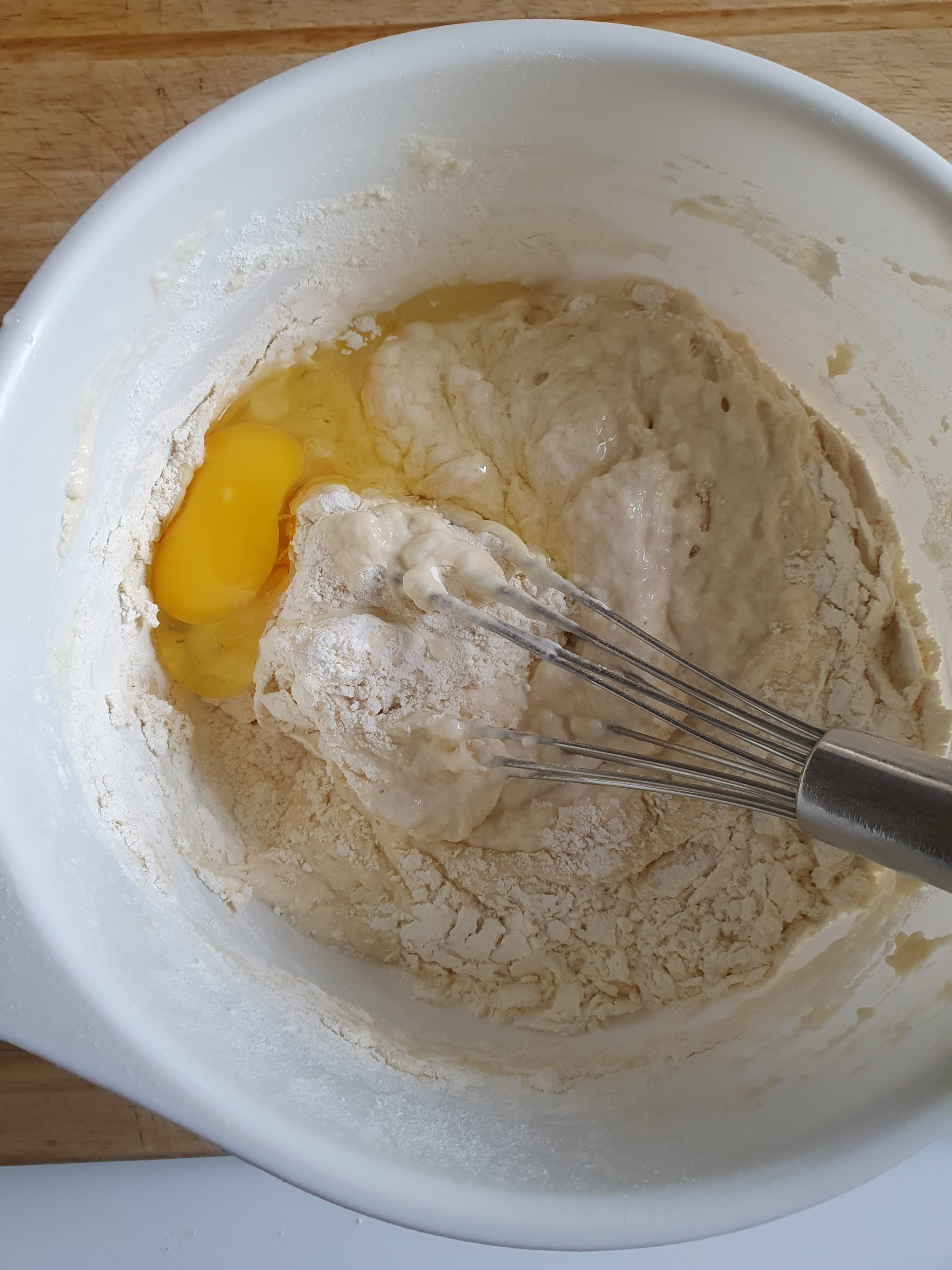 Rührschüssel mit Mehl, Eiern und Schneebesen