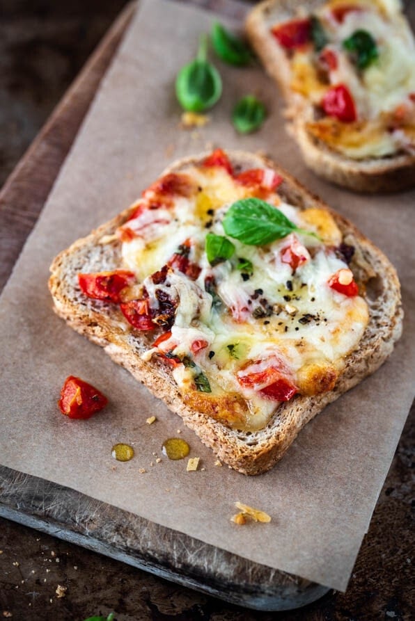 Toast überbacken liegt auf einem Holzbrettchen mit Backpapier.