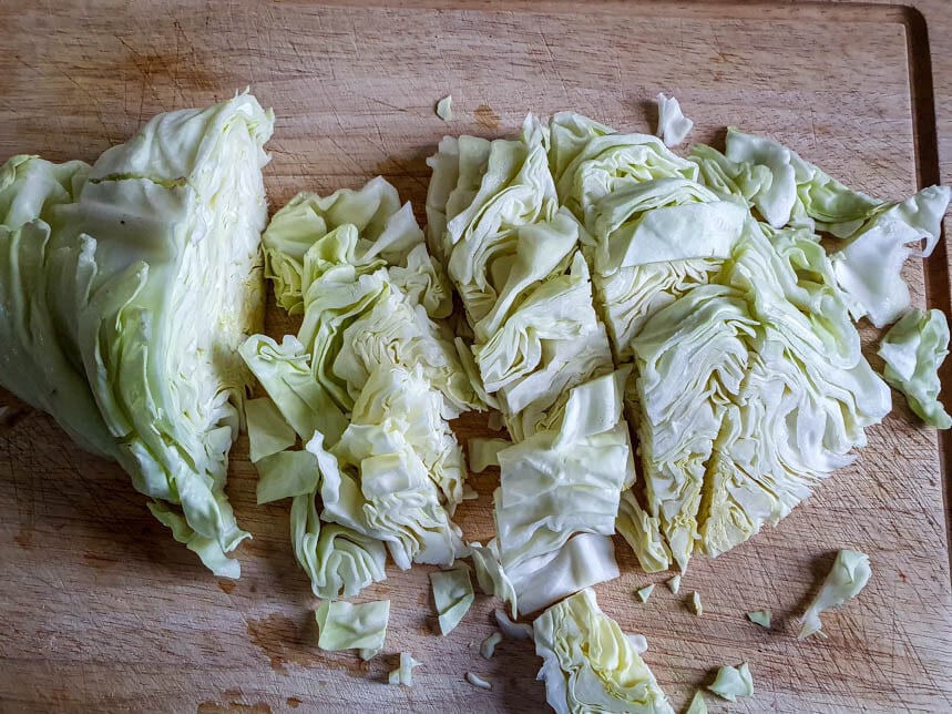 Klein geschnittener Spitzkohl liegt auf einem Schneidebrett.