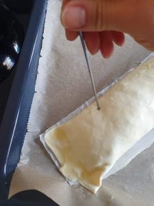 Mit einem Spieß werden Löcher in einen Strudel gestochen.