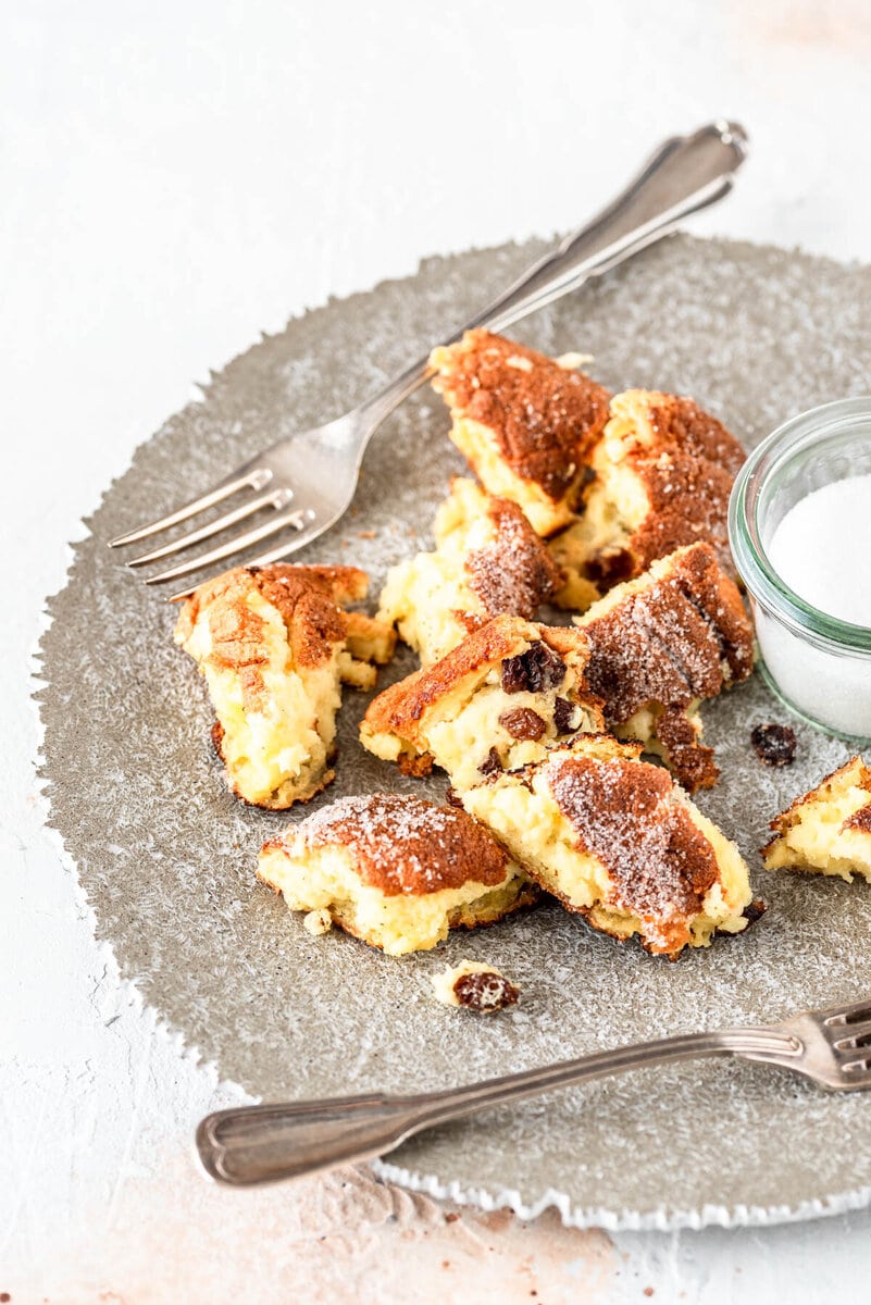 Ein Teller mit Kaiserschmarrn und Zucker auf hellem Untergrund