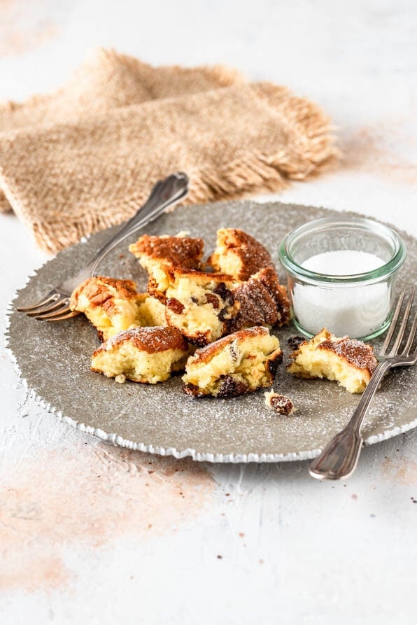 Ein Teller mit Kaiserschmarrn und Zucker auf hellem Untergrund