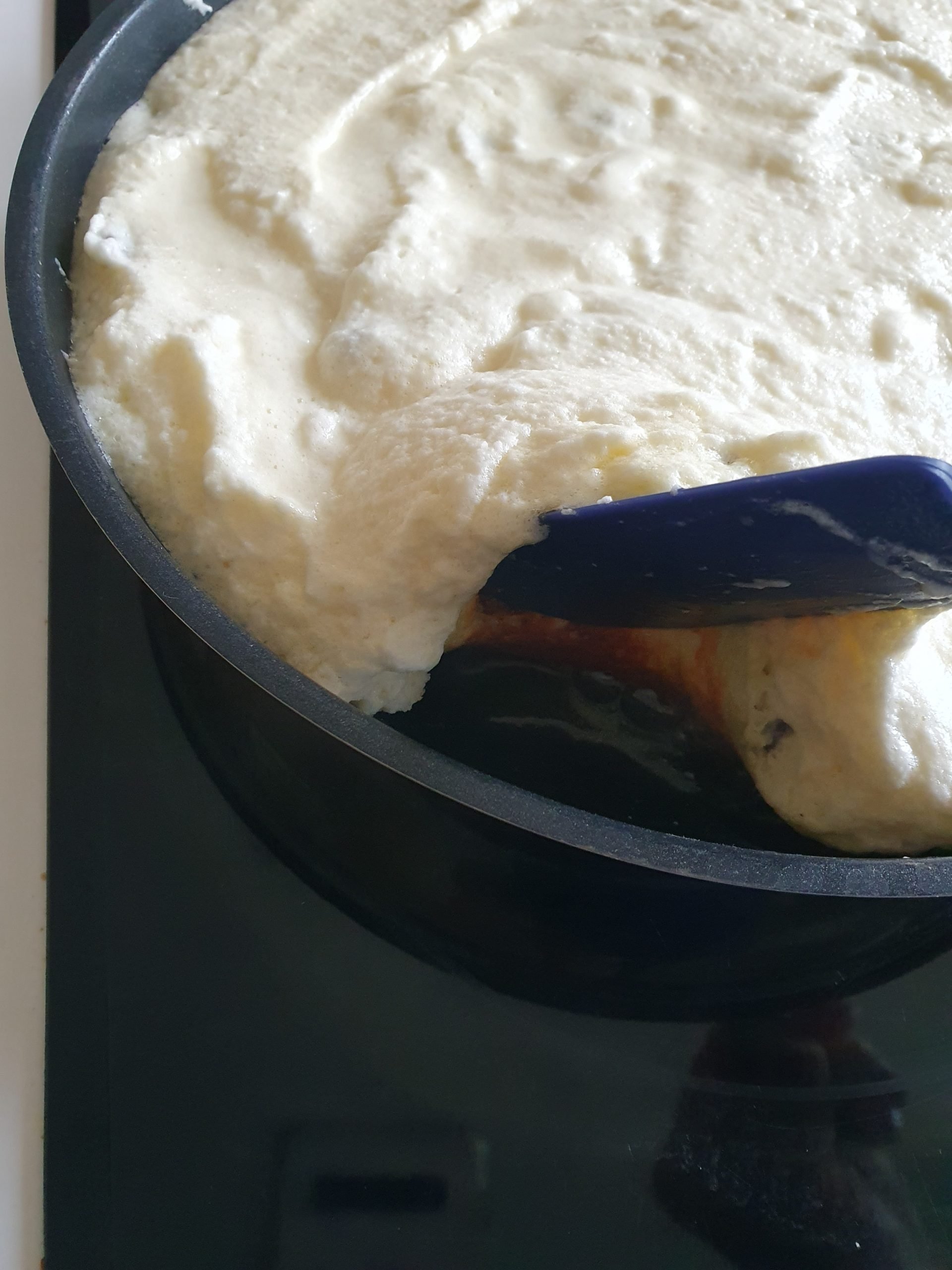 Teigmasse in Pfanne wird mit Pfannenwender angehoben.