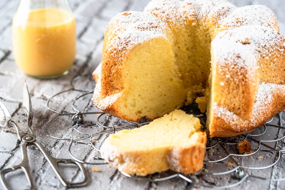 Angeschnittener Eierlikörkuchen auf einem dekorativen Metallgitter