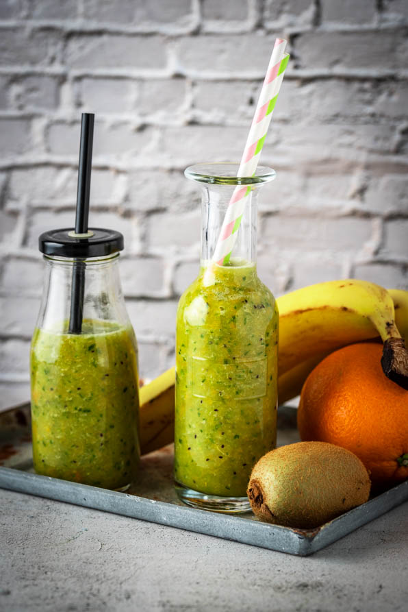 Obst mit zwei Flaschen Smoothies.