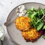 Kartoffelrösti mit Kräuterquark und Salat auf einem Teller