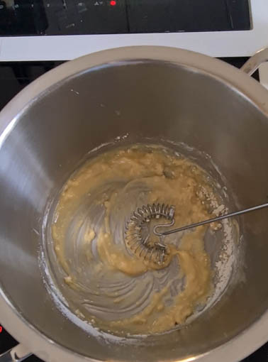 Mehl und Butter mit Rührbesen in einem Kochtopf.