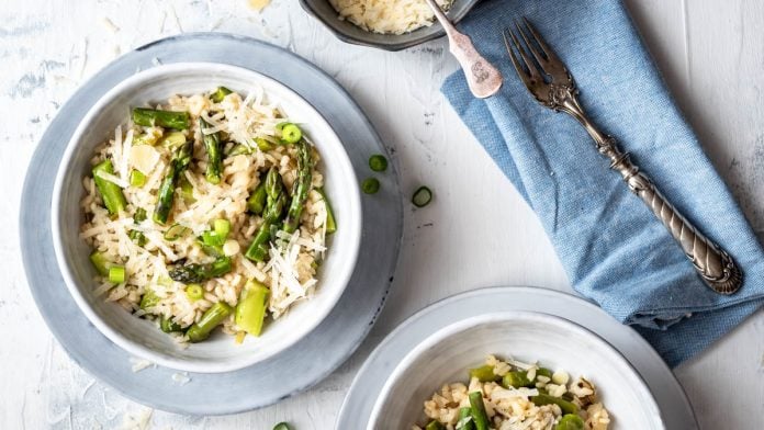 Ein Teller Spargelrisotto mit Parmesan und einer Serviette.