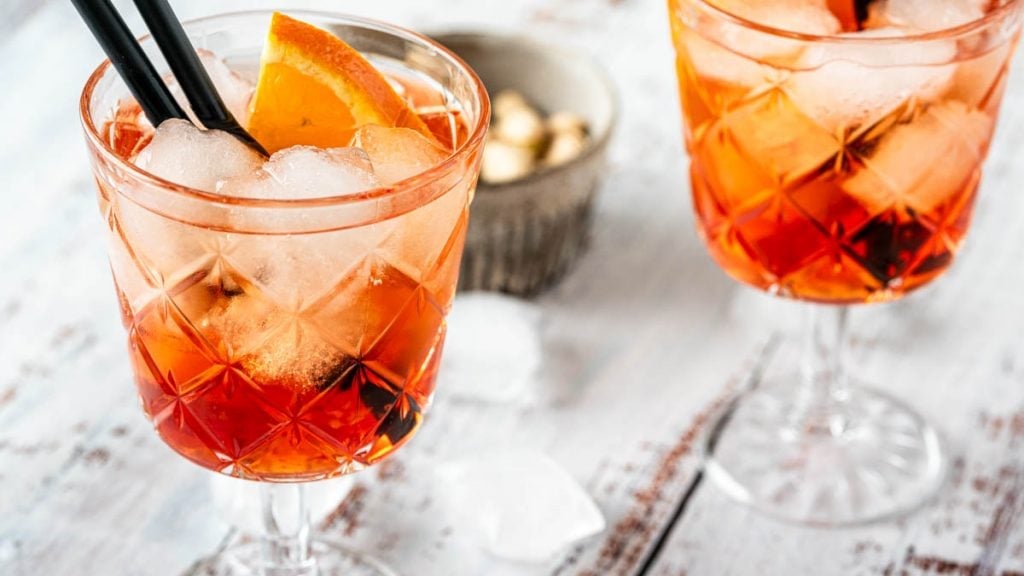 Zwei Gläser Aperol mit Eis und Strohhalm