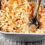 Eine Schüssel amerikanischer Krautsalat und Salatbesteck auf Holz