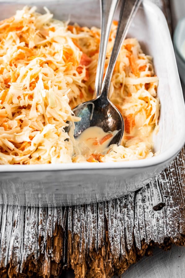 Eine Schüssel amerikanischer Krautsalat und Salatbesteck auf Holz