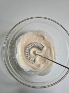 Eine Schüssel mit Mayonnaise und Rührbesen