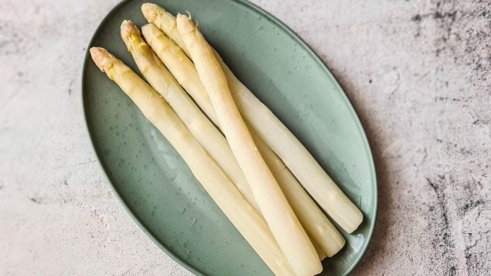 Ein ovaler Teller mit gekochtem Spargel