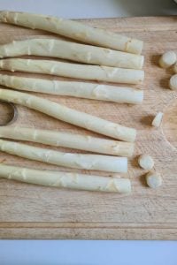 Spargelstangen liegen auf Holzbrett