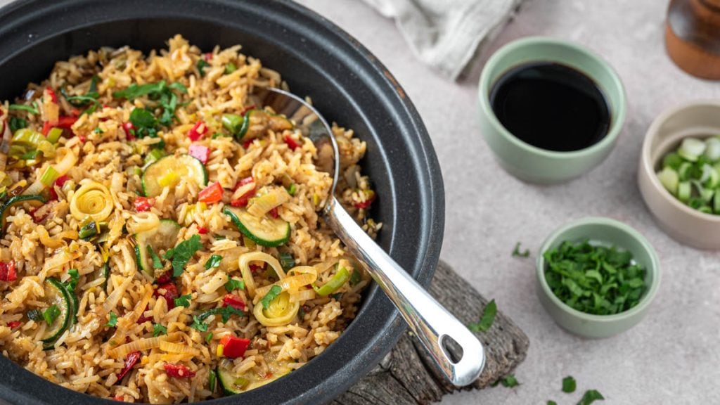 Eine Pfanne mit gebratenem Eierreis und Kräutern