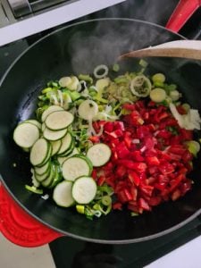 Gemüse wird in Bratpfanne gegeben