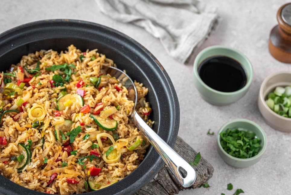 Eine Pfanne mit gebratenem Eierreis und Kräutern