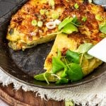 Angeschnittene spanische Tortilla in Pfanne mit Kräutern