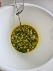 Salatdressing mit Rührbesen in Schüssel