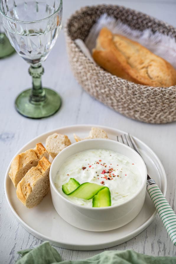 Tzatziki mit Baguette und einem Glas Wein am Tisch