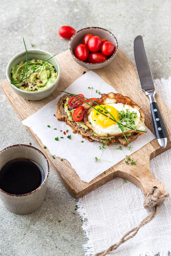 Strammer Max vegetarisch mit Avocado und Tomaten auf Holzbrettchen