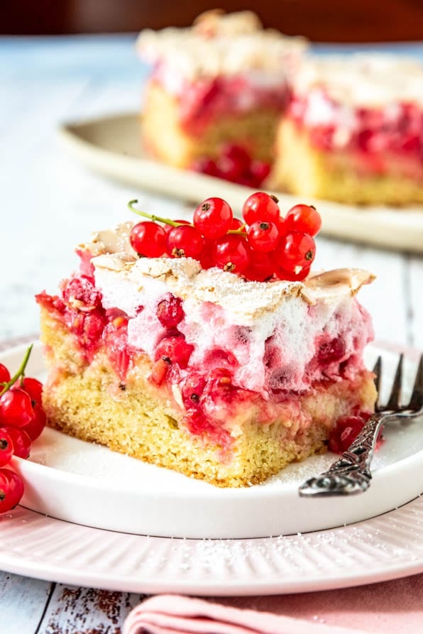Ein Stück Johannisbeerkuchen auf einem Teller und einer Gabel.