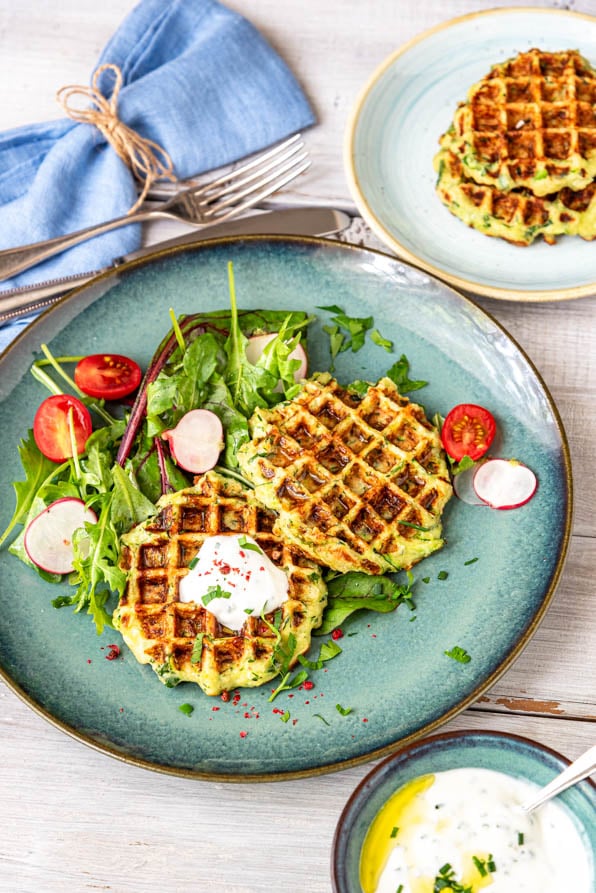 Herzhafte Waffeln mit Zucchini und Dip auf einem Teller