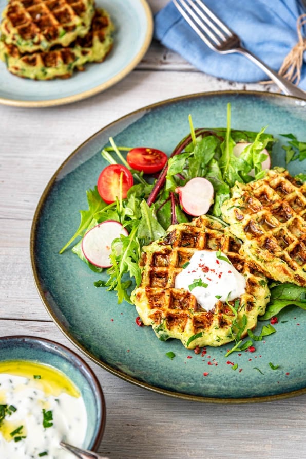 Herzhafte Waffeln mit Zucchini und Dip auf einem Teller